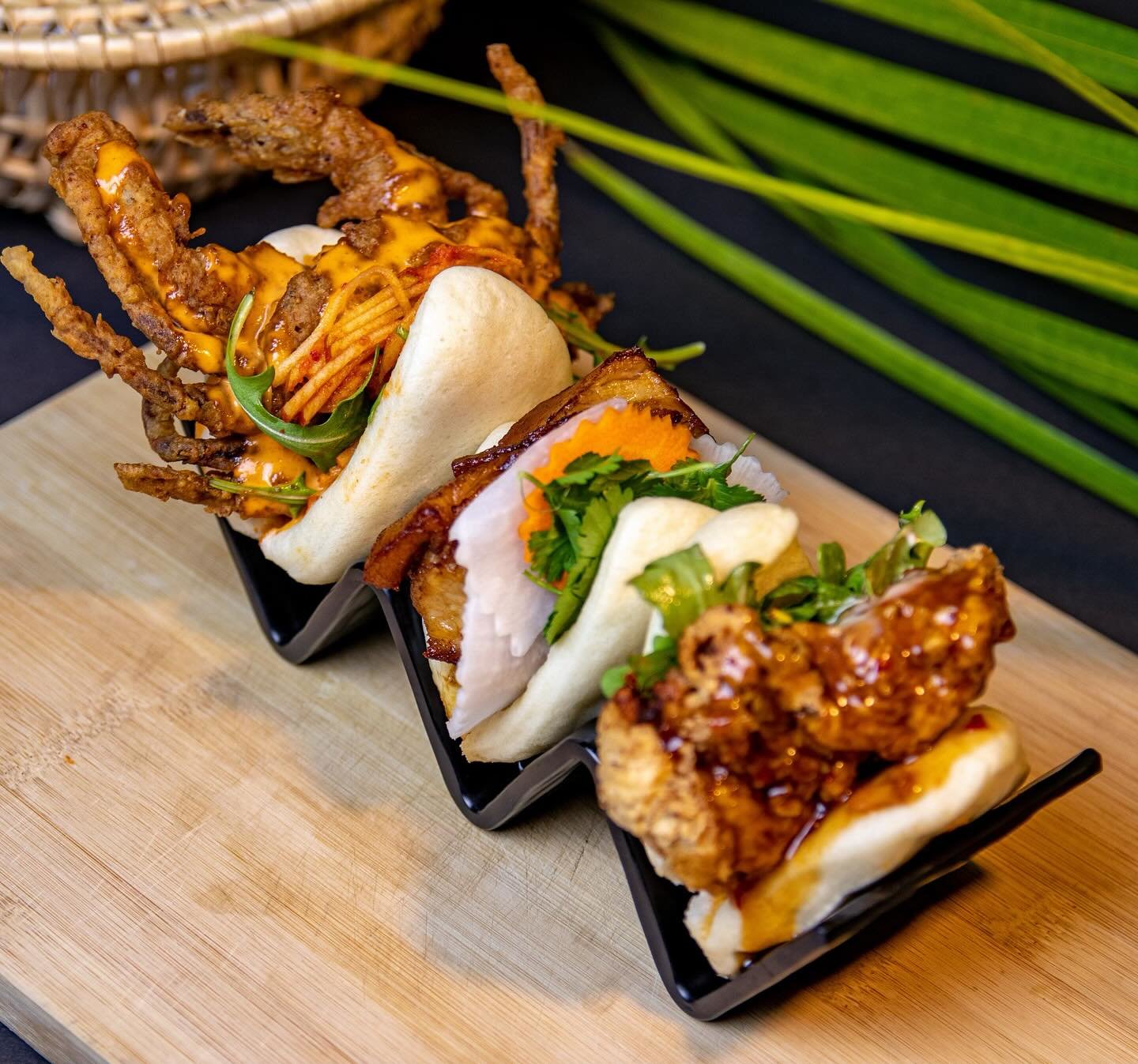 three bao on a black plate like holder